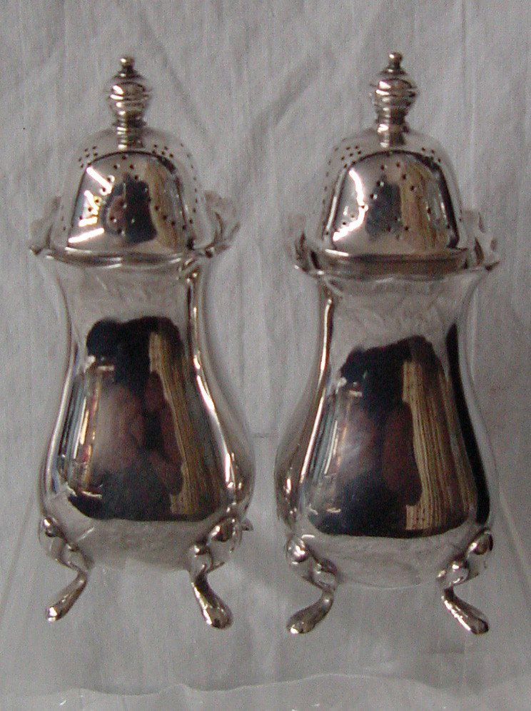 A Pr. Ellis Barker Salt & Peppers: Mark of the Menorah from 1912 for Ellis Barker of England, classical design, excellent condition, selling as a pair, 4" tall by 1 1/2" wide at the feet. The lids are in excellent condition.