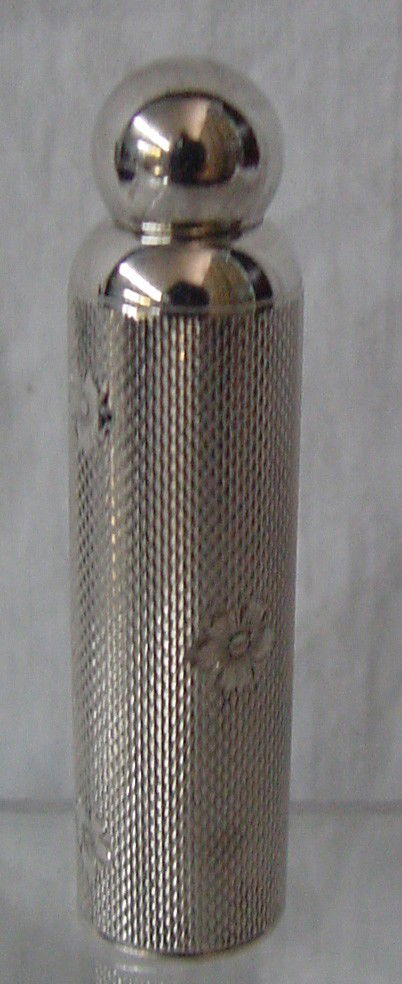 A German Sterling Art Deco Perfume Bottle: Round cylinder sterling perfume bottle with knob top, pure Art Deco, textured surface and engraved flower design, 2 1/4" long by 1/2" wide. Stamped on the base Sterling Germany, probably 1920s era.