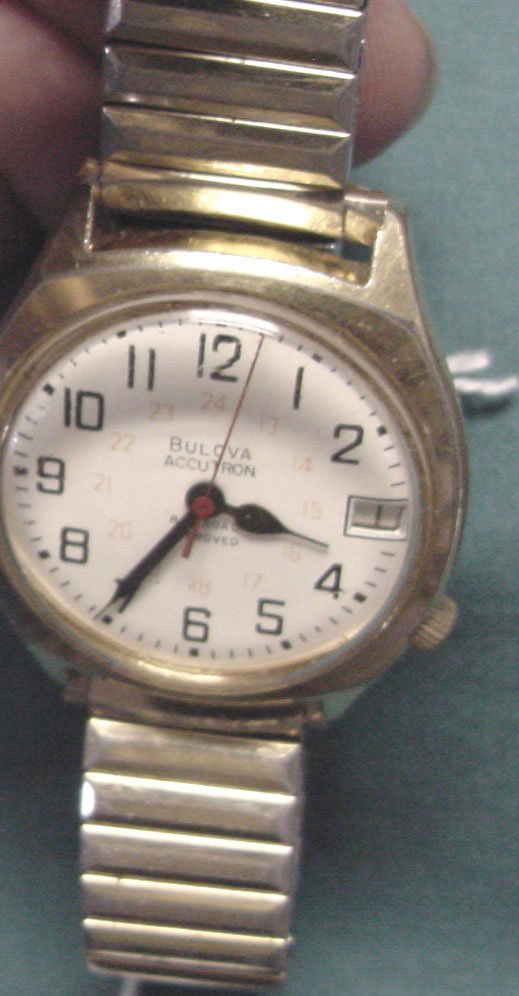 A Bulova Accutron RR Wrist Watch: On the round face of this wrist watch is Bulova Accutron, Railroad Approved, red sweep second hand, pale red second numbers behind the black numbers in an inner circle, calendar movement advances with