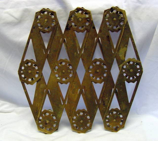 A Brass 19th Cent. Trivet: Expandable braded trivet with snowflake designs, good condition, probably 1880-1910 era, 10" tall, 7 1/2" wide when completely closed, and will expand to 24" long for a large platter, 1/2" tall. Large