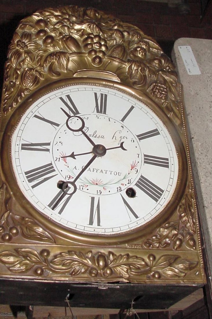 French Mobier Wag On Wall Clock: Repousse work brass area around the enamel painted face, ornate large pendulum hanging from the works, old if not original weights, on the face is written: Balssa L or H ger and A. Gaffattou, Roman nu