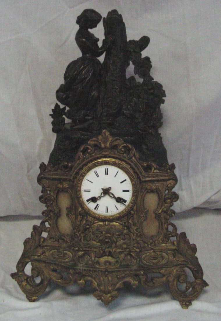 19th Cent. French Clock: Stamped FF and a French movement, brass base with side lights of Carmel colored stained glass beside the face, the upper section is a faux bronze image of a young woman standing beside a tree trunk en