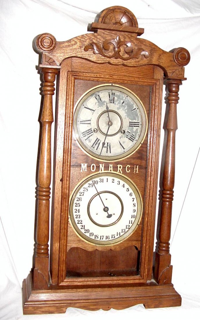 Oak Monarch Calendar Clock Knoxville, Tn: 1880-1910 era, old refinished Oak case, Monarch in gold stencil on the front original tablet, painted tin face with Roman Numeral numbers with some flaking, base calendar movement is in really good co