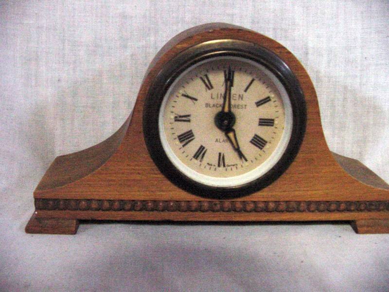 Cuckoo Mfg. Camel Back Mantle Clock: Probably from the late 40s early 1950s era, miniature camel style in blonde Mahogany, on the face is Linden Black Forest Alarm Made in Germany, 3" tall by 6 1/4" long.