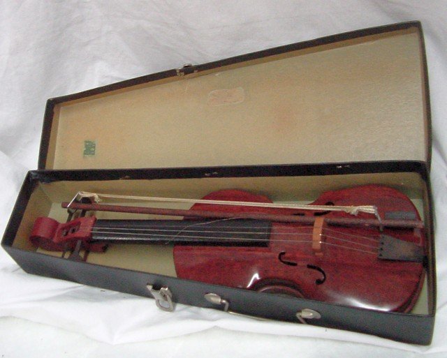 Childs Tin Miniature Violin: Faux wood grained finish on what appears to be tin, original black painted area behind the strings, all 4 keys are intact on the top, original cardboard fitted box with handle, some damage to the clas