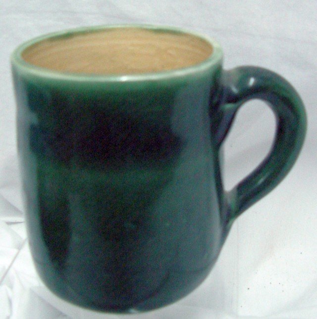 Pisgah Forest Pottery Cup: Green glaze with tan interior, marking of Pisgah Forest and date marking of 1950, 3 3/4" wide and tall including the handle.