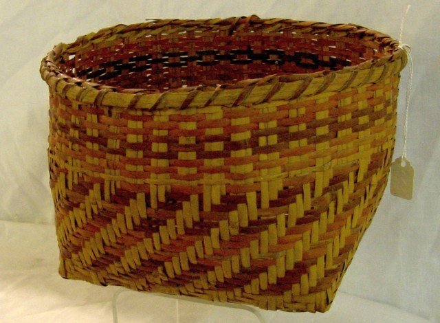 Cherokee River Cane Round Basket: 8 3/4" wide by 5 3/4" tall, square base, diagonal bands woven in a semi herringbone pattern, double stave weaving on a band below the top, blood root, brown and natural river cane, pattern decorated o
