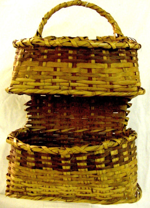 Choctaw Split Woven Basket: Double Basket with one stacked and woven on top of the other, walnut stain with normal river cane color, 11" wide by 5" deep by 17" tall, 1940s. Made to be hung on a wall.