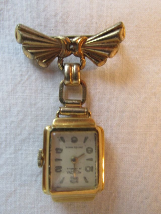 Medana Swiss 15 Jewels Ladies Hanging Watch: Probably 1950s retro era, hanging from a stylized bow yellow gold filled pin, Medana Swiss movement, 15 jewels, currently not running, 1 7/8" tall including the pin, 1 1/4" wide.