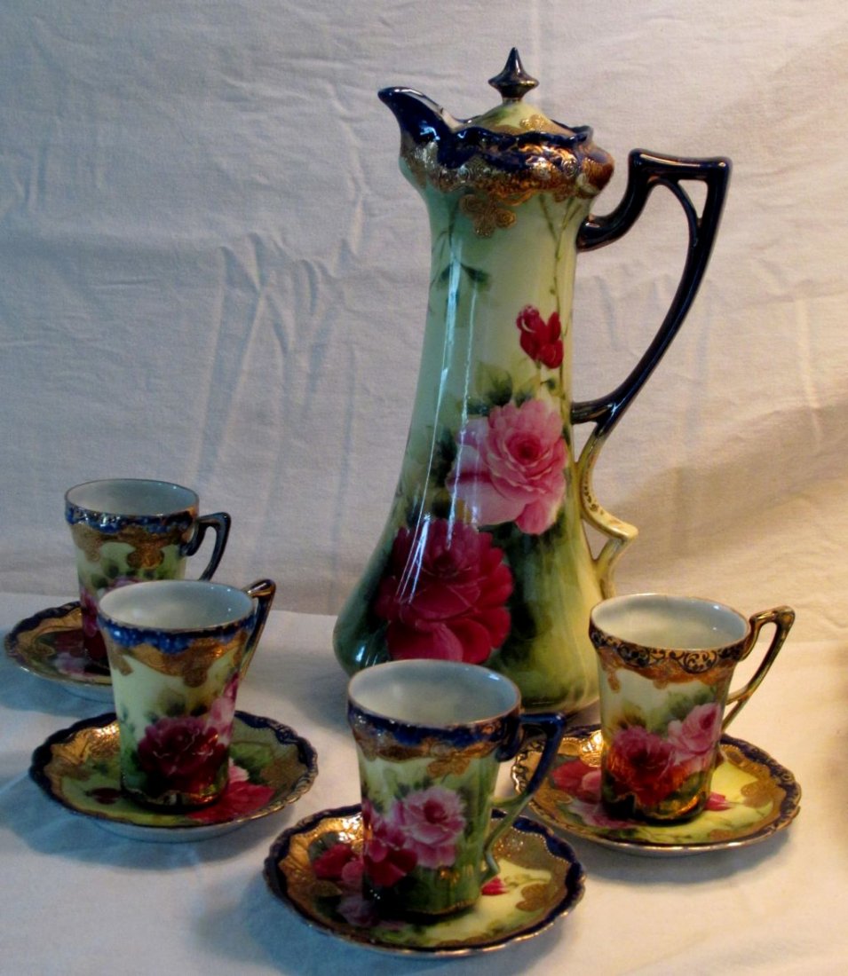 Nippon Chocolate Set: Elegant unmarked Nippon with cobalt blue and gold trim, hand painted pink and red flowers, 1880-1910 era, set consists of tall chocolate pot, 4 cups and saucers. Pot is 11 3/4" tall by 5" wide across 