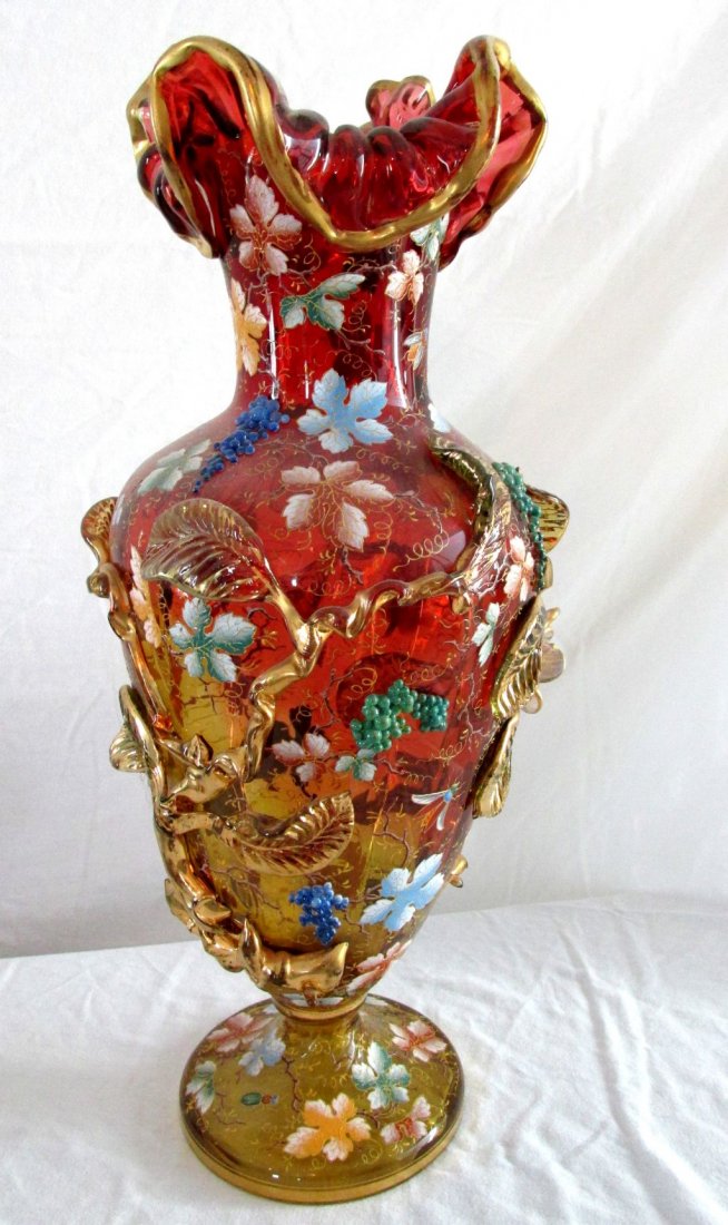 Moser Type Art Glass Vase: Early 20th Century, Amberina style glass, with cranberry colored glass at the top and shading into gold at the base, enamel painted leaves, applied gold glass leaves, applied blue/purple grapes, sprin
