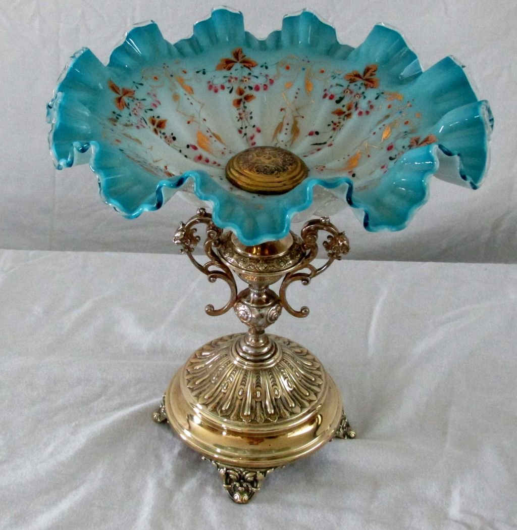 19th Cent. Art Glass Bowl On Stand: Blue hand blown cased glass bowl with gold and floral decorations, clear ribbon on the sides of he fluted edge, ornate brass base with animal heads on the handles, unmarked but likely to be 1870-1890 