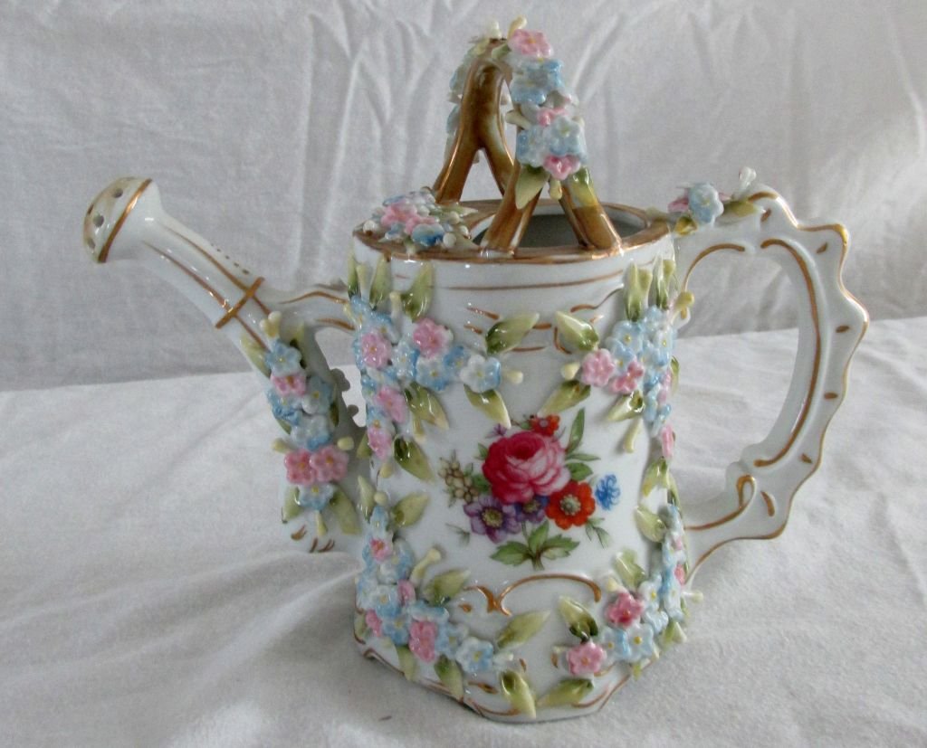 Porcelain Floral Watering Can: Probably German, 1920s or 30s era, applied flowers in porcelain all over the can, handle and spout area of the piece, applied handle. No country of origin on bottom but M -11 in red. 6 1/2" tall by 7