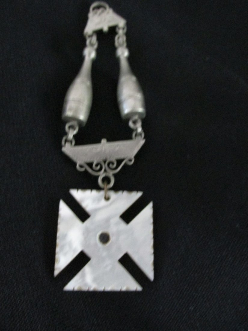 Nazi? Fob w/MOP & Bowling Pins: Probably a Nazi fob, white mother of pearl cross hanging from what appears to be a white metal, possibly unmarked silver with engravings, hanging from 2 bowling pins. There is no marking whatsoever on