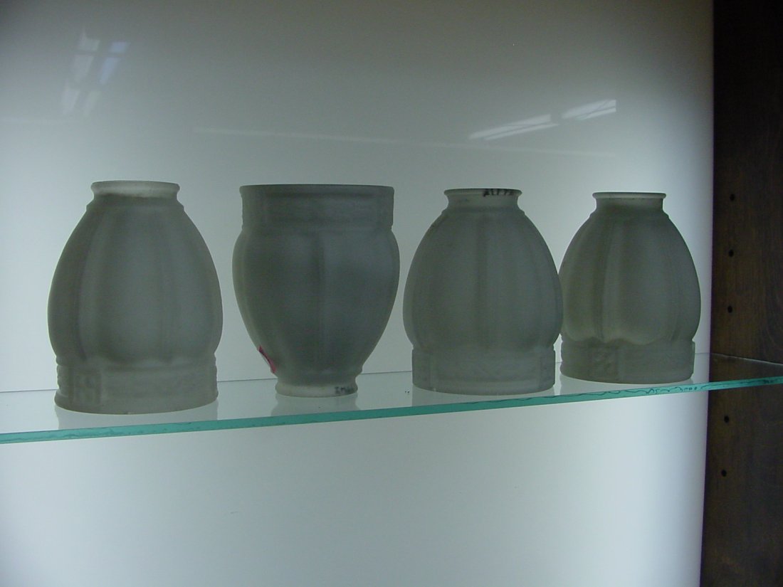 4 Gas Shades: 4 shades matching 2 1/4" fitter, 5 3/8" tall, 4" wide across the bottom, white glass with panels and floral border on the base. One of the shades has a spider crack in the side. Paint flakes on the ri
