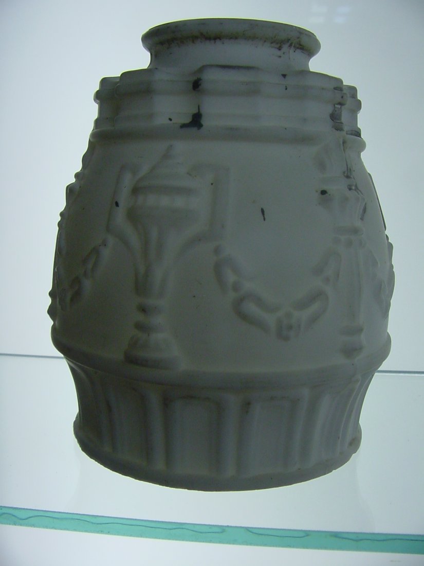 Gas Shade: 2 1/4" fitter, 5" tall, 3 3/4" diameter, molded garland with torches and urns heavily embossed in the white satin glass., Small base exterior nick.