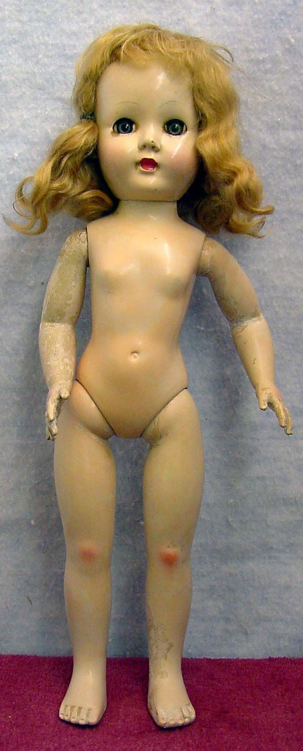 EFFANBEE Doll: 13 in. tall plastic socket head on plastic body. She has green sleep eyes with upper lashes and painted lower lashes, closed mouth, and appears to be a mohair wig. She is jointed at the shoulders and