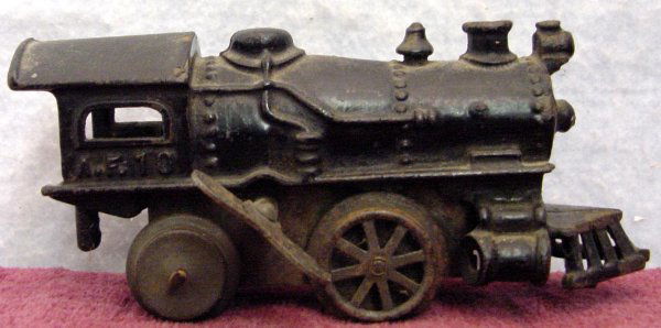 Cast Iron Wind Up Train Engine: 6 in. long and 2 in. tall made of cast iron, when wound up the wheels will turn, however if the train is set down they will not turn, with a minor tune up I am sure this old toy will run like new agai