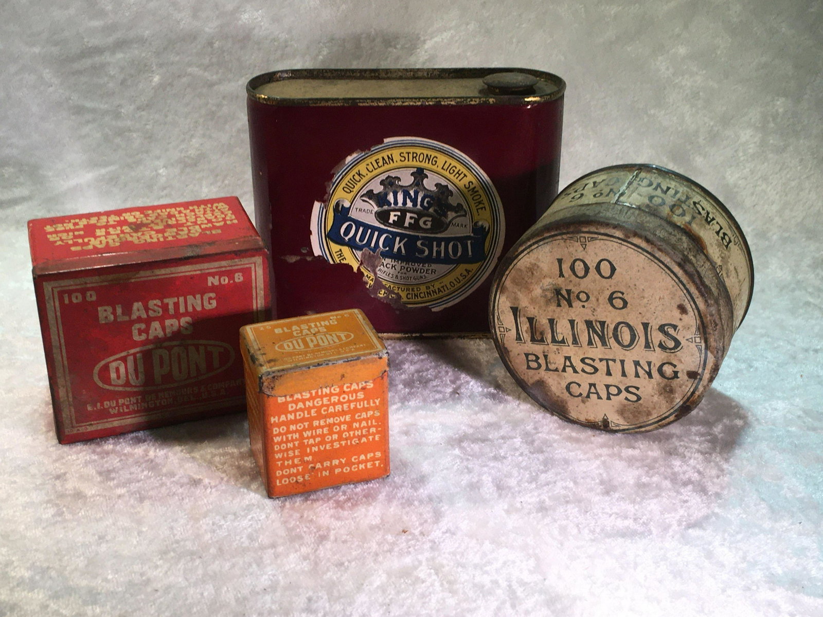 Lot of (4) Powder & Blasting Cap Tins. Quick Shot: Lot of (4) Powder & Blasting Cap Tins. Quick Shot Powder, (Powder Tin) Dupont Blasting Cap Tin, (25Ct), Dupont Blasting Cap Tin, (100 Ct.), Illinois Blasting Caps,Tin, (100 ct) & Hercules Blasting Cap