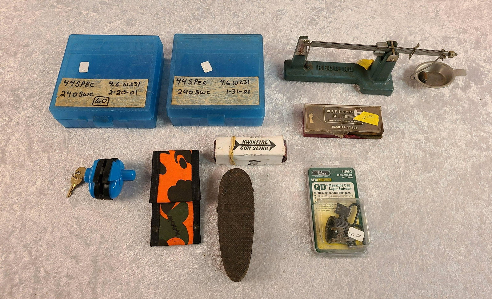 Box Lot of Reloading Equipment: Box Lot of Reloading Equipment: (2) MTM Case Gard 44 Spec./45 long Colt Cartridge Boxes, Gun Lock, Redding Powder Scales, Recoil Pad, Gun Slig, Dressing Knife, Wet Stone, Uncle Mike Swivels for 1100 R