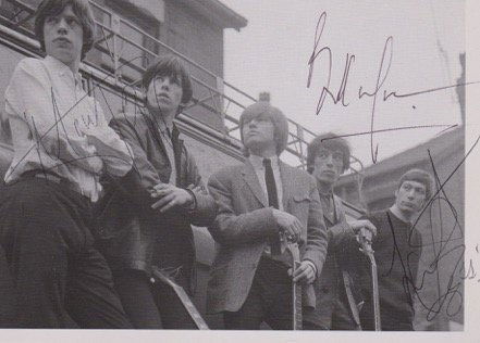 The Rolling Stones.: This is an original 1960’s photograph of The Rolling Stones which is 16 3/4 cm by 12 cm. This has been signed by Mick Jagger, Bill Wyman and Charlie Watts and comes with a separate Brian Jones autog