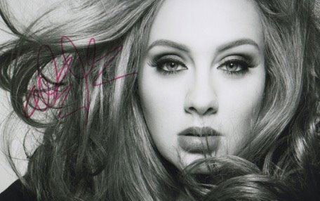 Adele Signed Photograph.: An 11 inches by 8 inches close up portrait of singer Adele signed by her in Red sharpie colour pen to the left centre of the photograph. In fine condition and a lovely fluent signature.