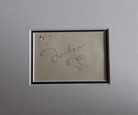 JOHN LENNON SIGNED.: A mounted John Lennon signature with doodle. Supplied with coa with authentication certification number.