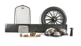 FORD ITEMS Lot of Ford items including a new sto: Lot of Ford items including a new stone guard radiator cover for a 1930-31 Ford; a group of brass Model T Ford hubcaps; four late 1930s Ford hubcaps featuring the V8 crest; a NOS Model T running board