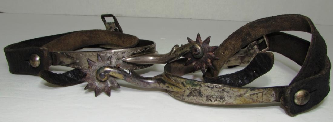 ANTIQUE HANDMADE NAVAJO STERLING SILVER SPURS: CIRCA 1900 SPUR WITH LEATHER BOOT STRAPS. OVERALL LENGTH MEASURES 5" WITH 3" INSERT LENGTH AND 2 5/8 BOOT ENTRY POINT. BEAUTIFUL SIMPLE HAND STAMPED DESIGN. 1" WIDE 10 POINT ROWEL. NO MARKINGS.