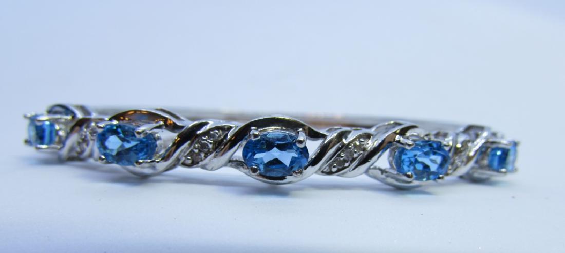 BLUE TOPAZ DIAMOND BANGLE BRACELET STERLING SILVER: GENUINE GEMSTONES; 5MM BY 7MM FINE BLUE TOPAZ ACCENTED WITH 12 DIAMONDS. BANGLE WILL FIT A 7 1/4 INCH WRIST. WEIGHS 14.4 GRAMS. ALL EXCELLENT CONDITION, WITH SAFETY CHAIN AND LOCK. (USA SHIPPING $8)