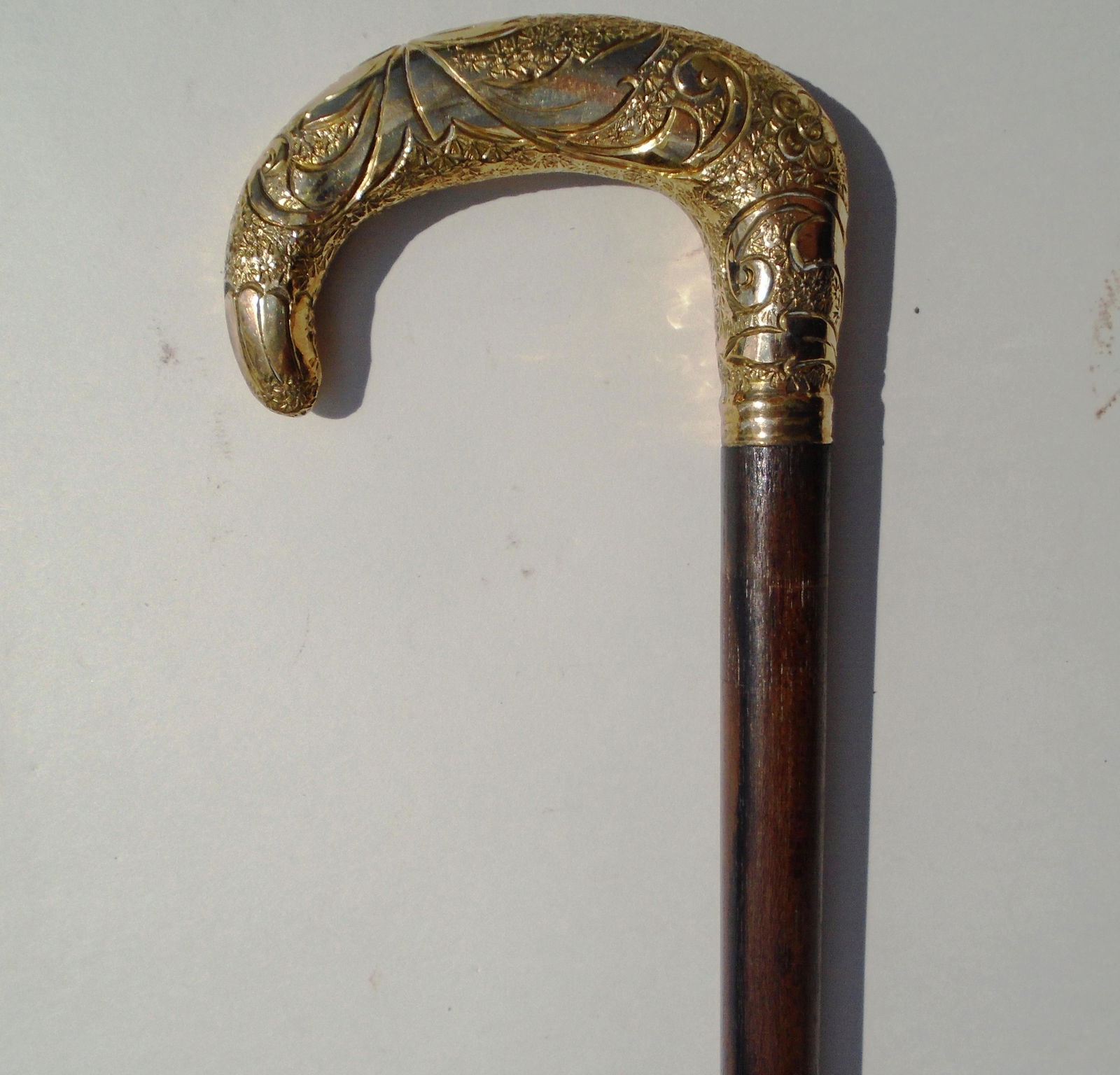 GOLD TOP PRESENTATION CANE WOOD HOOK REPOUSSE: ANTIQUE GOLD TOPPED WALKING STICK WITH WOOD SHAFT. TOP 4 1/4" WIDE, 2 7/8" TALL. 35" OVERALL. ENGRAVED J H E.(US SHIPPING $25)