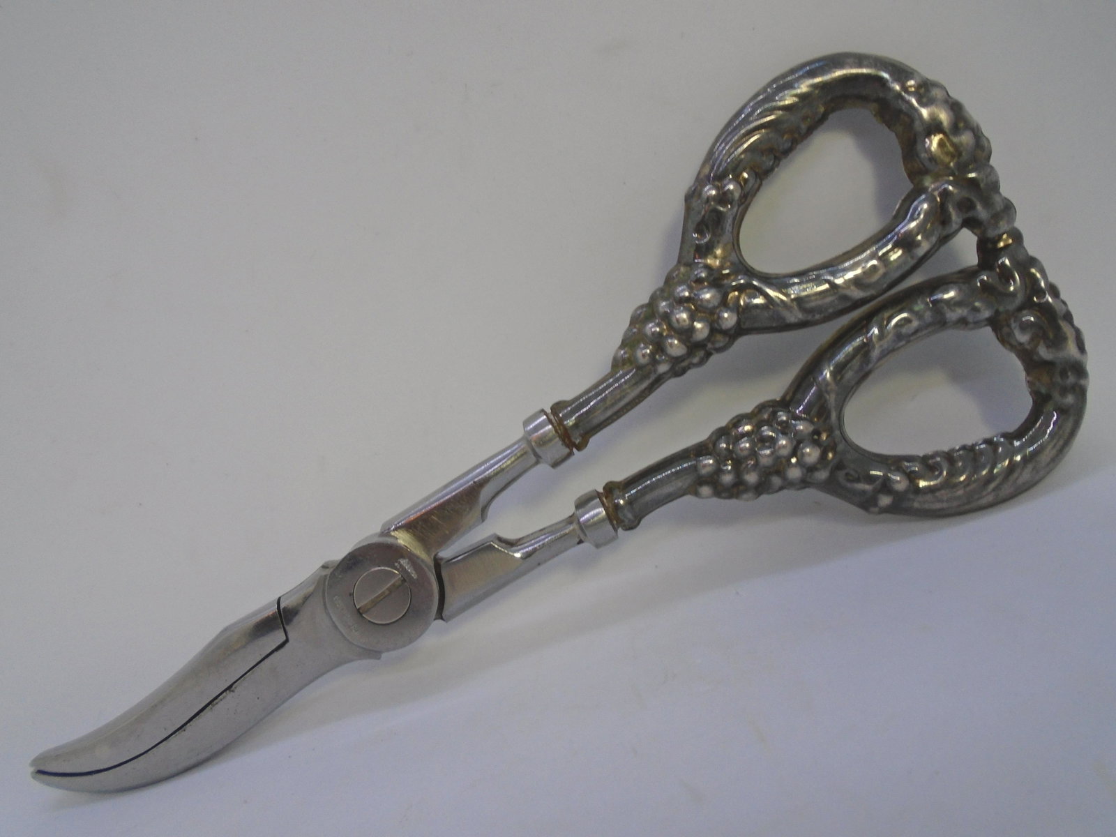 ANTIQUE STERLING SILVER GRAPE SHEAR SCISSORS: FLORAL GRAPEVINE DESIGN MARKED STERLING ON SCISSOR HANDLES ARE STERLING. BLADES MARKED STAINLESS ITALY. TOTAL WEIGHT 82 GRAMS. MEASURE 6 1/2" LONG. EXCELLENT CONDITION ANTIQUE. (US SHIPPING $10)