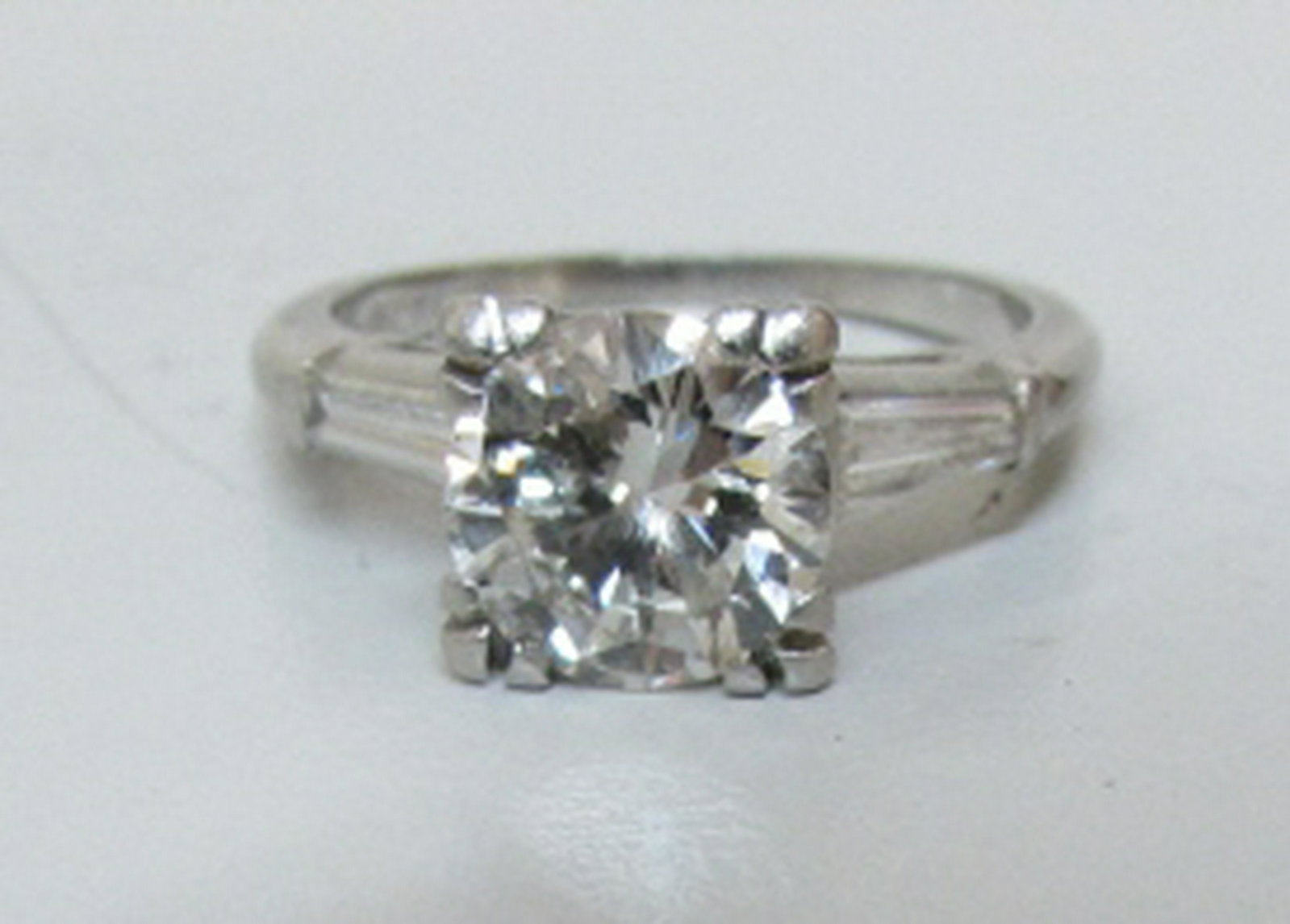 1.64CT VS G DIAMOND PLATINUM RING: DIAMOND ENGAGEMENT ROUND SOLITAIRE 7.4MM BY 4.1MM: 1.44CT VS CLARITY, G-H COLOR WITH 2 TAPERED BAGUETTES (.20CT). PLATINUM MOUNTING 4.4 GRAMS SIZE 5. VINTAGE ESTATE RING IN EXCELLENT CONDITION. (US SH