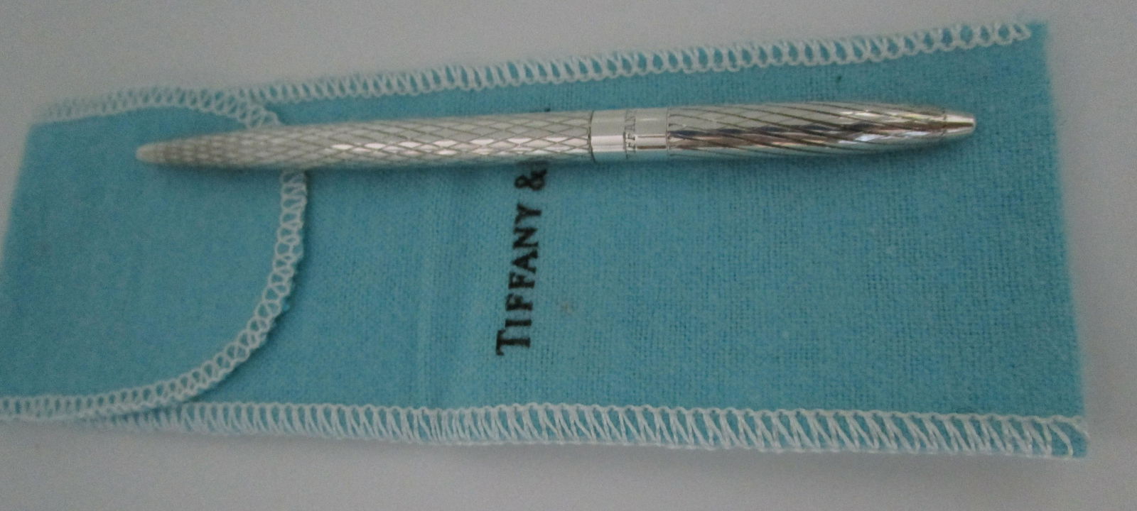 TIFFANY & CO PEN STERLING SILVER W POUCH: GENUINE SIGNED "TIFFANY & CO STERLING SILVER" VINTAGE ESTATE 4 1/2 INCHES LONG. WEIGHS 12.3 GRAMS. EXCELLENT LIKE NEW CONDITION IN TIFFANY POUCH. BLUE INK. (USA SHIPPING FREE)