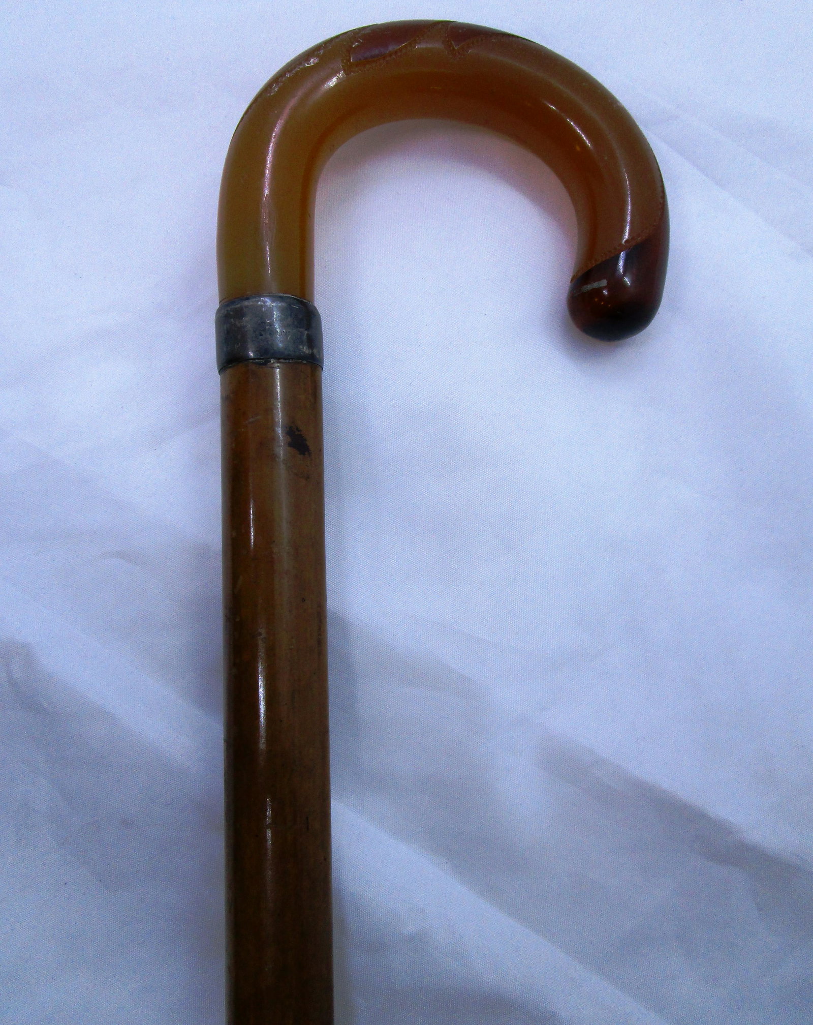 BAKELITE CANE WOOD ANTIQUE STERLING COLLAR: WOOD CANE w/ BAKELITE HANDLE, STERLING SILVER COLLAR, HORN TIP. 4" WIDE, 35.25" TALL. SHIPPING 25