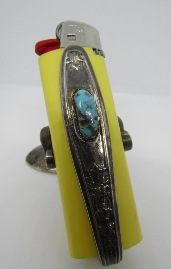 TURQUOISE LIGHTER SILVER SPOON & FORK CREATION: GENUINE TURQUOISE STONE NATIVE AMERICAN WORK OF ART. 3" TALL BY 3" WIDE. A FORK WAS BENT TO HOLD THE LIGHTER AND THE SPOON BOWL MAKES THE BASE. ROGERS SILVERPLATE WEIGHS 47.4 GRAMS. CAN NOT SHIP THE L