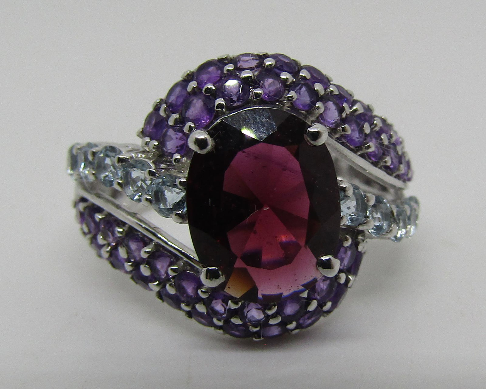 GARNET AMETHYST AQUAMARINE RING 14K WHITE GOLD: GENUINE 10MM X 8MM GEM RED GARNET SURROUNDED BY 10 AQUA MARINE AND 44 AMETHYST. MARKED "585" GOLD, WEIGHS 5 GRAMS. 15.8 MM WIDE. SIZE 8. EXCELLENT CONDITION VINTAGE ESTATE. USA SHIPPING $8