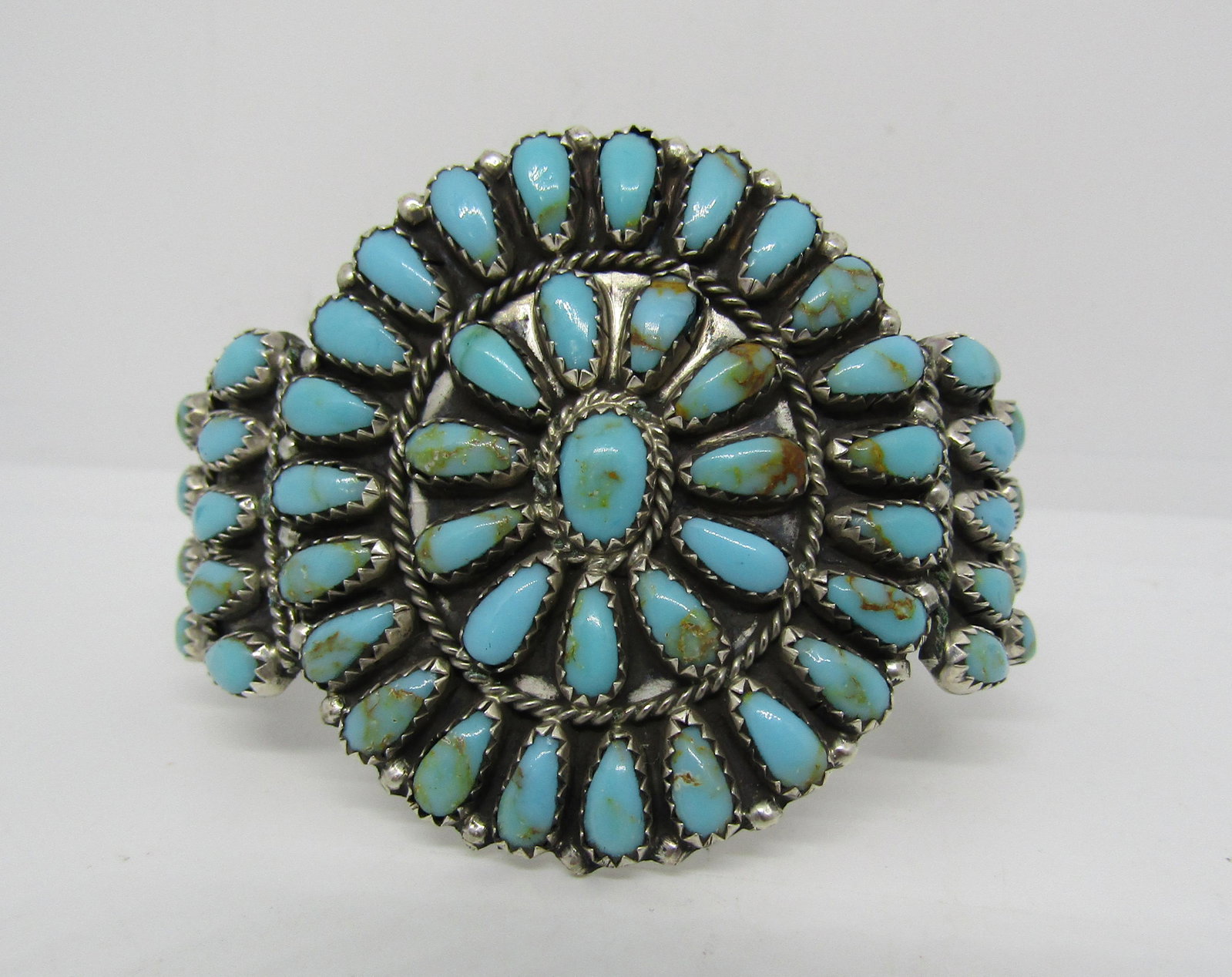 LARRY MOSES BEGAY PETIT POINT TURQUOISE BRACELET: SIGNED "LMB STERLING". GORGEOUS CLUSTER BRACELET IN STERLING SILVER MADE BY NATIVE AMERICAN NAVAJO ARTISAN LARRY MOSES BEGAY. VINTAGE PIECE. WEIGHS 25.8 GRAMS. HAS 5" INNER CIRCUMFERENCE, 1-1/4" GAP, 