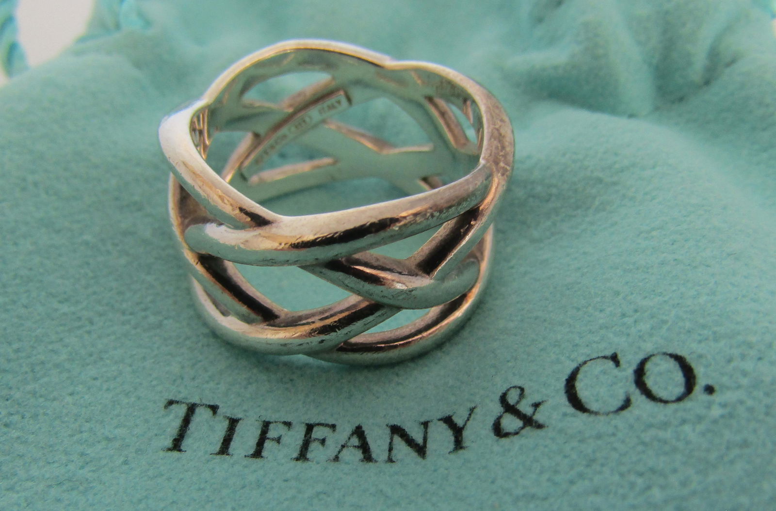 TIFFANY & CO CELTIC RING STERLING SILVER W POUCH: GENUINE SIGNED "T& CO. 925". CELTIC KNOT WEAVE SIZE 6 1/2. MEASURES 12.5MM. WEIGHS 8.4 GRAMS. WITH TIFFANY POUCH. EXCELLENT USED CONDITION. USA SHIPPING $5.