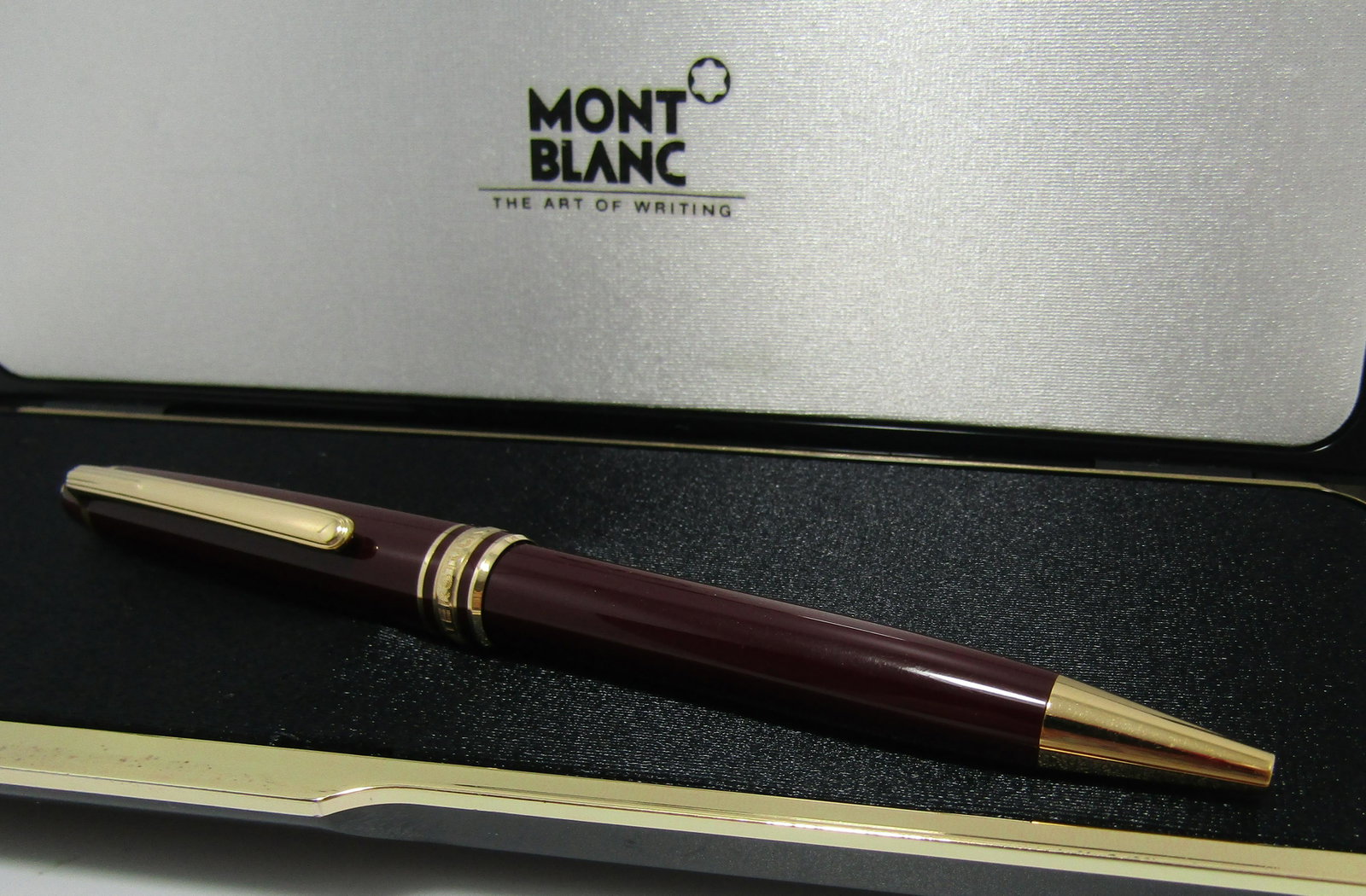 MONTBLANC PEN 14K GOLD BAND W GERMANY MEISTERSTUCK: GENUINE MONT BLANC MEISTERSTUCK BALL POINT BORDEAUX PEN. MARKED W. GERMANY. CENTER MEISTERSTUCK BAND TESTS 14K YELLOW GOLD. MEASURES 5 1/2 INCHES LONG. WEIGHS 22 GRAMS TOTAL. BLUE INK, VINTAGE ESTATE 