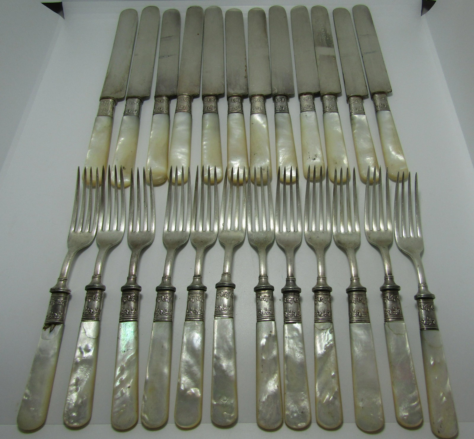 MOP STERLING & SILVERPLATE LANDERS FRARY FISH SET: FLATWARE MARKED "LANDERS, FRARY, CLARK AETNA WORKS" 24 PIECE SET OF MOTHER OF PEARL HANDLE FORKS AND KNIVES. WITH MARKED "STERLING" SILVER FITTINGS AND SILVERPLATE BLADES AND FORKS. ANTIQUE USED CONDI