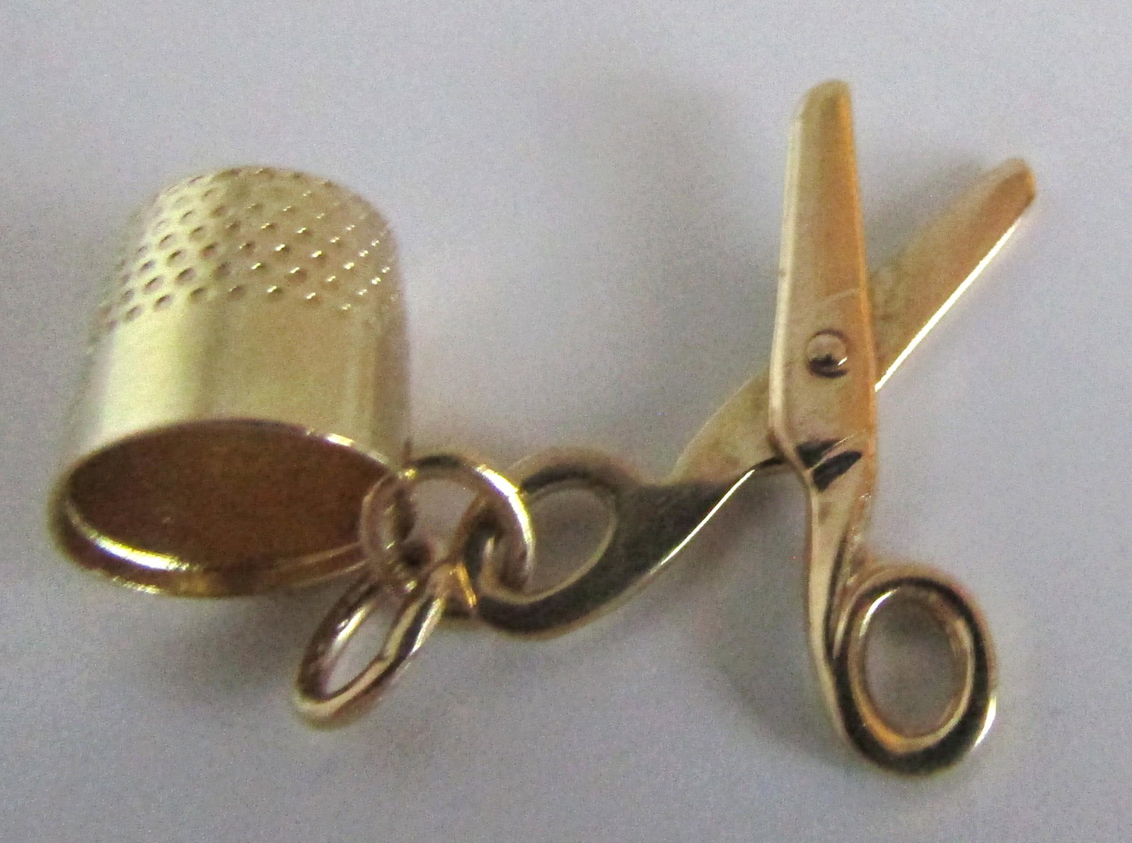 JMF14K GOLD CHARM SCISSOR & THIMBLE PENDANT SEWING: VINTAGE ESTATE BOTH PIECES HALLMARKED "JMF 14K" FISHER YELLOW GOLD WEIGH 2 GRAMS. THIMBLE 10MM AND SHEARS (MOVEABLE, OPEN AND CLOSE) 19MM. EXCELLENT CONDITION. USA SHIPPING $5.