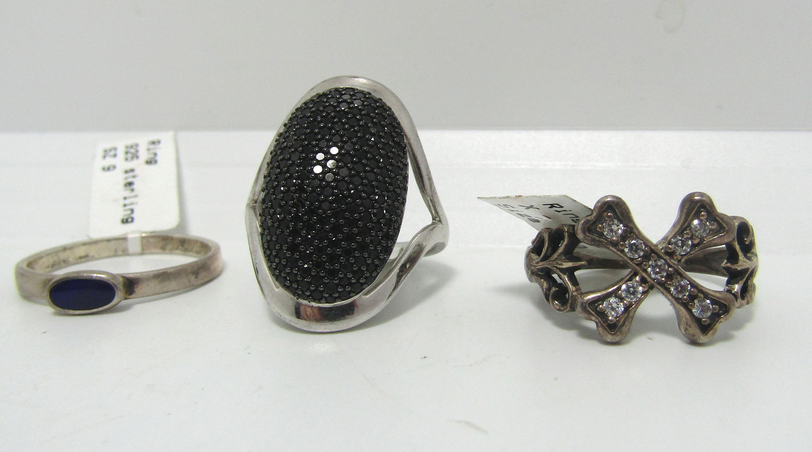 LOT OF 3 STERLING RINGS ONYX CZ CROSSBONES SZ9: ALL TESTED & MARKED 925 STERLING SILVER VINTAGE CONDITION. X MARKS THE SPOT CROSSBONES PIRATE RING IS RING SIZE 9.75, OTHER TWO ARE SIZE 9. ONYX RING MARKED CHINA. RETAIL TAGS SHOW $119 TOTAL. WEIGH 1
