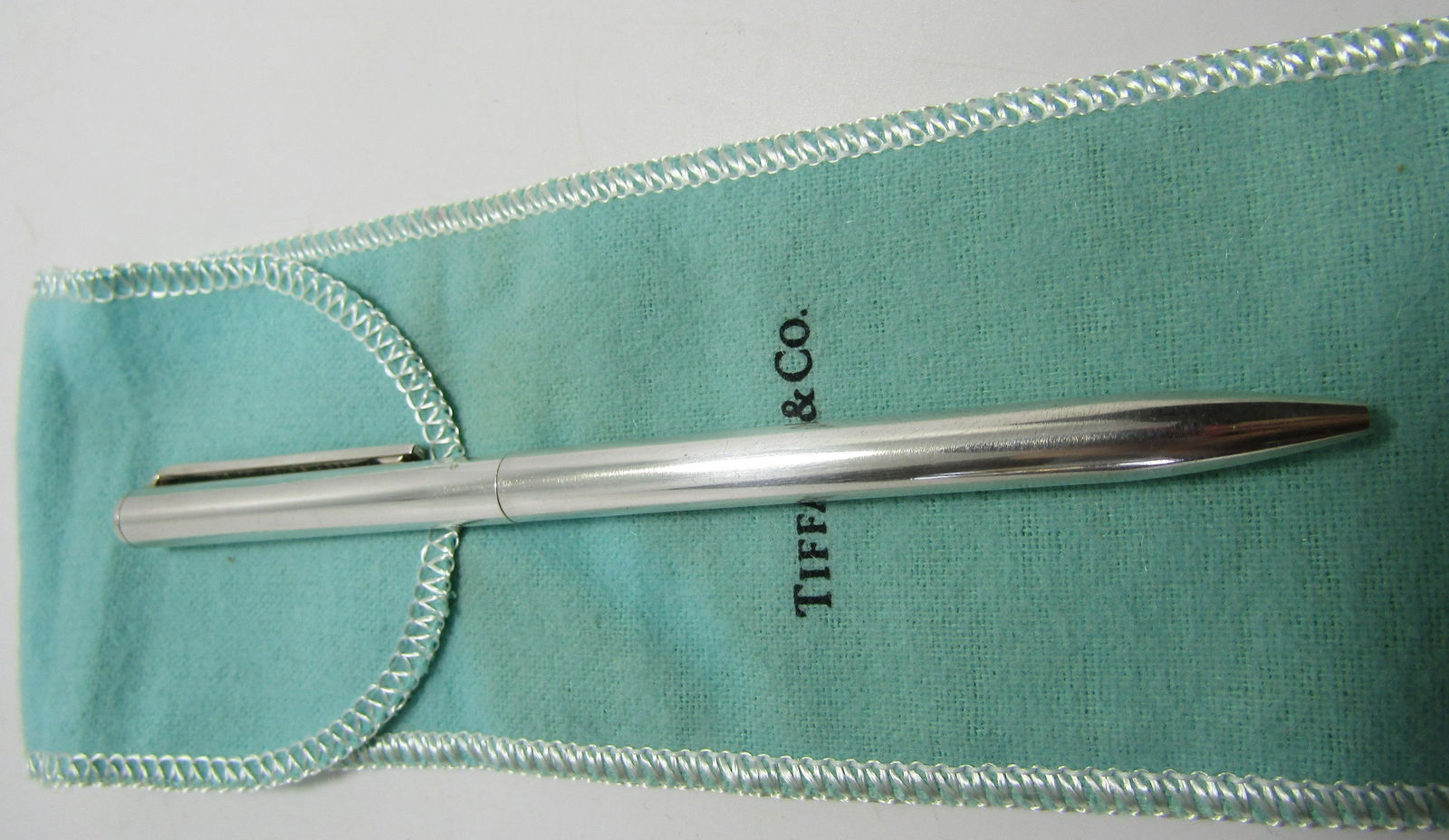 TIFFANY & CO PEN STERLING SILVER W POUCH: GENUINE SIGNED "TIFFANY & CO 925 USA". MEASURES 5 1/4 INCHES LONG. EXCELLENT CONDITION. WEIGHS 23.5 GRAMS. BLUE INK. COMES WITH A TIFFANY POUCH USA SHIPPING $5.