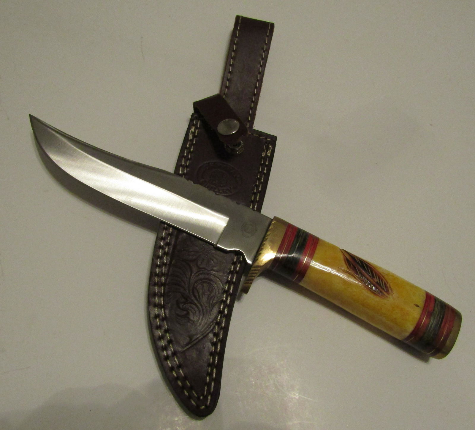 CHIPAWAY BOWIE HUNTING KNIFE: LARGE 12 1/4 INCH KNIFE WITH7 INCH BLADE 1 1/4 INCH WIDE WITH BARVED BONE AND LEATHER GRIP WITH BRASS HILT AND BUTT CAP.