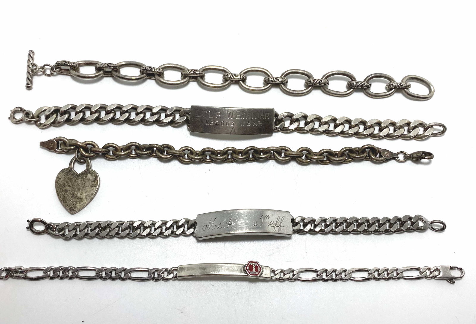 140 GRAM LOT OF 5 STERLING CHAIN BRACELETS: 3 ID OR MEDICAL BRACELETS. ONE MARKED "LCDR W.E. HUJAR USNR LOVE MOM AND DAD 1941". HEART BRACELET. LONGEST IS 8". ALL TESTED STERLING SILVER. 140 GRAMS TOTAL. USA SHIPPING $5.