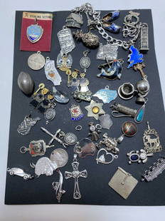 117 GRAM LOT STERLING SILVER 50 CHARM BRACELET: LARGE LOT OF APPROXIMATELY 50 STERLING CHARMS WITH ONE BRACELET. INCLUDES INTREPID CARRIER MUSEUM, INDIANA, EIFFEL TOWER, PINEAPPLE, DANISH ENAMEL CLOGS, OREGON, ENGLAND DOLPHIN NORTH CAROLINA