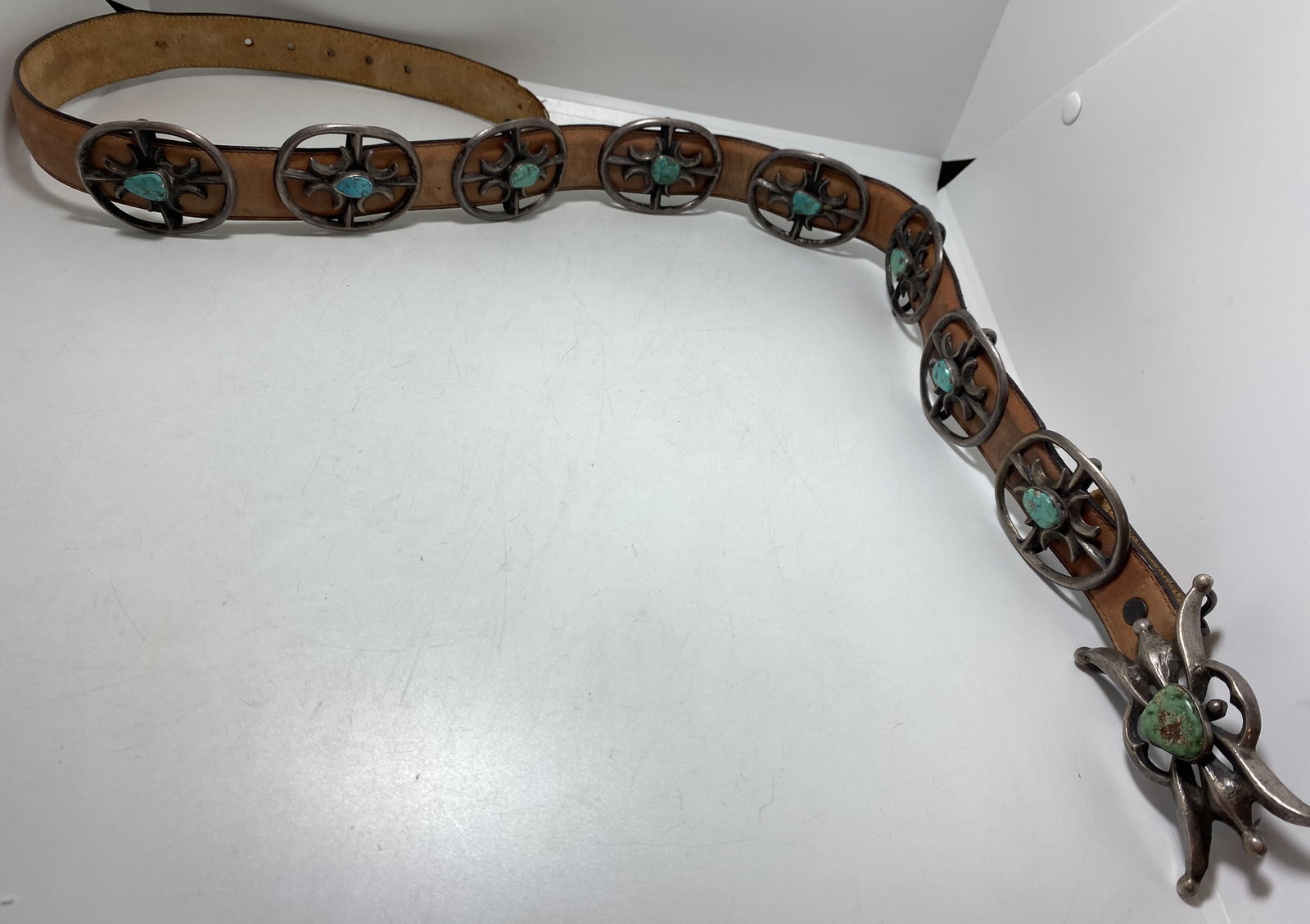 1970'S STERLING TUFA CAST CONCHO BELT TURQUOISE: OLD PAWN VINTAGE LIKELY 1970'S NATIVE AMERICAN NAVAJO HANDMADE CONCHO BELT. WAGON WHEEL DESIGN. UNSIGNED UNMARKED TESTED STERLING SILVER. SOME CONCHOS ARE LOOSE, COULD USE NEW LEATHER. WEIGHS 323 GRAM