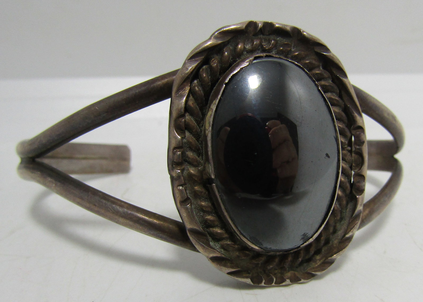 "PLC" HEMATITE CUFF BRACELET STERLING SILVER: ARTIST MARKED "CPLor PLC STERLING". VINTAGE ESTATE NATIVE AMERICAN SOUTHWEST NAVAJO INDIAN JEWELRY. TOP MEASURES 36MM WIDE. FITS A 7 1/2 INCH WRIST WITH A 31MM GAP. WEIGHS 31.5 GRAMS. EXCELLENT USED C