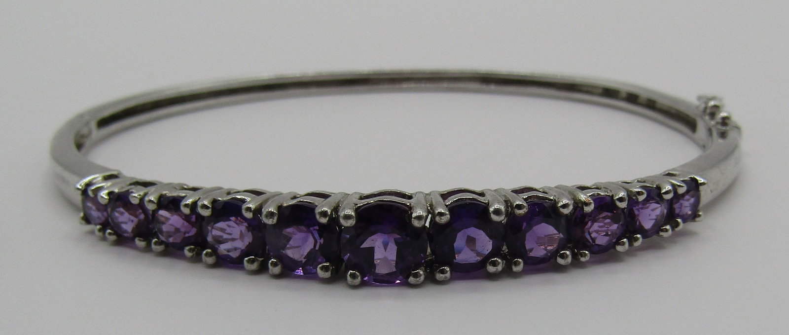 AMETHYST BANGLE BRACELET STERLING SILVER: GENUINE AMETHYST GEMSTONE BANGLE THAT OPENS FOR EASY ON AND OFF. VINTAGE ESTATE MEASURES 2.75 INCHES BY 2.5"; FIT A 7" WRIST. WEIGHS 12.6 GRAMS. EXCELLENT USED CONDITION. USA SHIPPING $5. NO INTERNATI